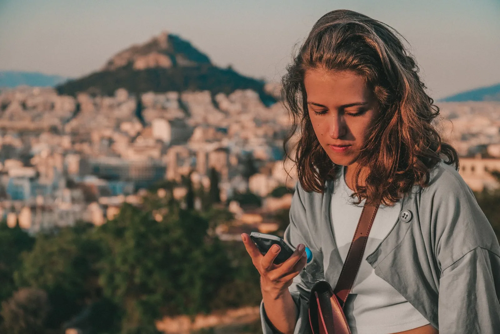 A woman checking her account on her phone in the city